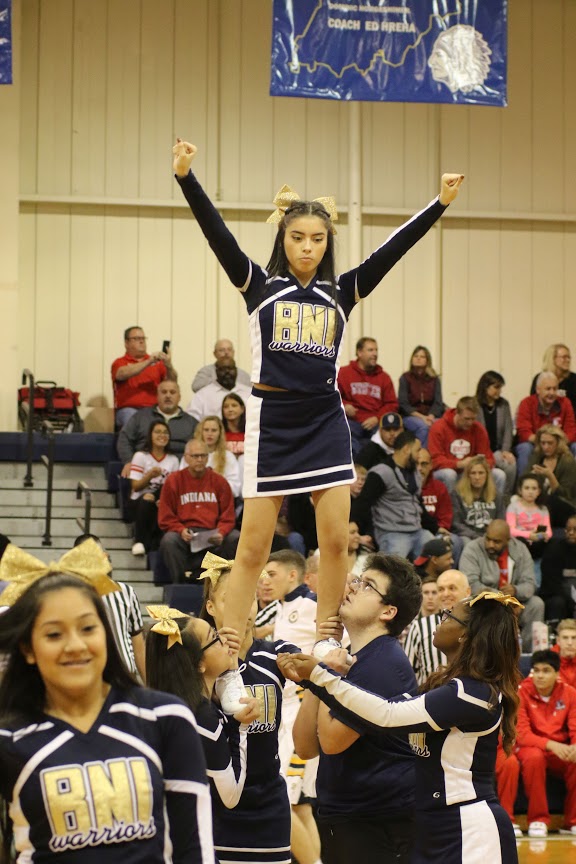 Dylan Meister Senior at Bishop Noll lifts Catia Salazar while performing at a home basketball game 