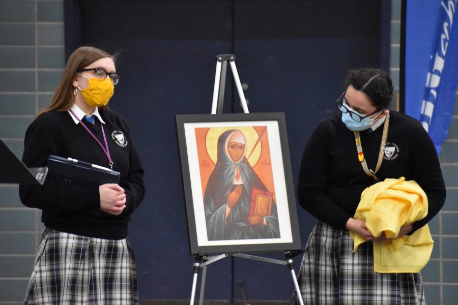 Junior Abby Wojtaszek and sophomore Sophia Mendez present the biography of Saint Katharina Kasper, the founder of the Poor Handmaids of Jesus Christ